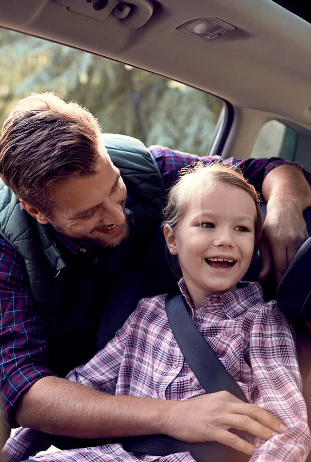 Father buckling child into car